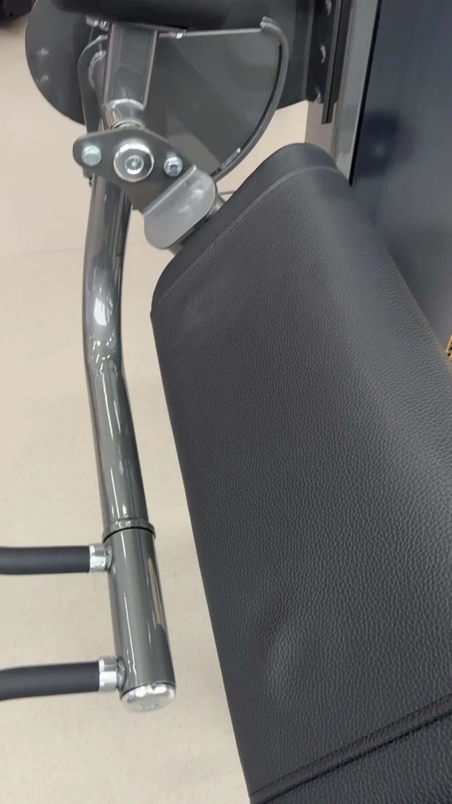 Original video frame showing a close view of INSIGHT equipment tubing, pivot hardware and upholstery detail.