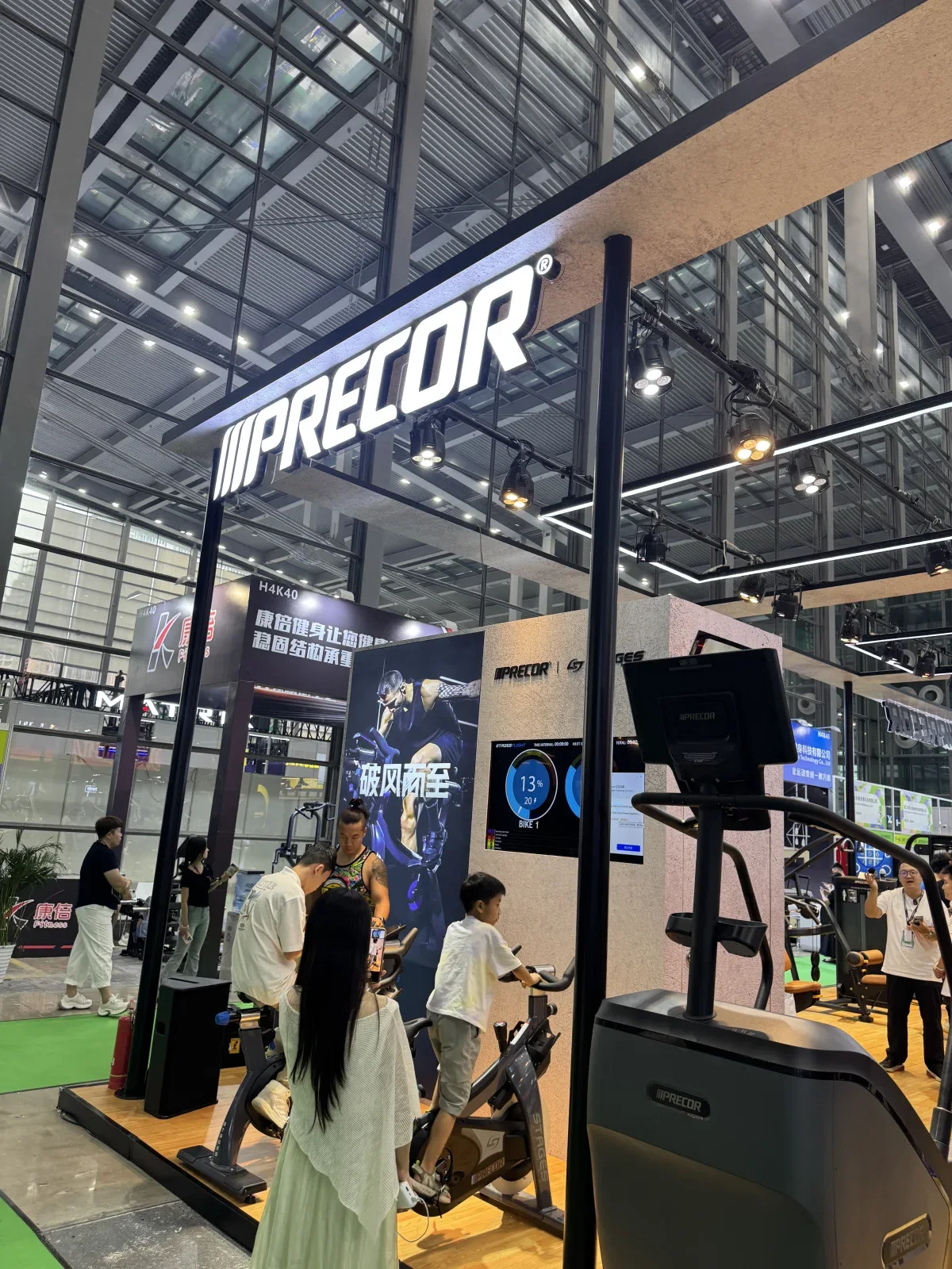 Original IWF Shenzhen photograph of the PRECOR booth and commercial cardio equipment used as a premium reference point.