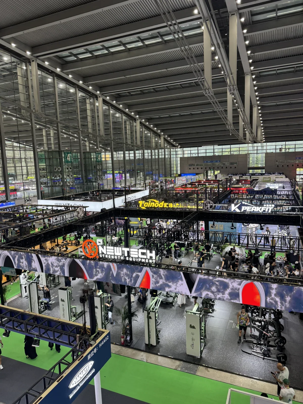 Original wide field photograph of the IWF Shenzhen 2026 exhibition hall with commercial fitness-equipment booths visible below.