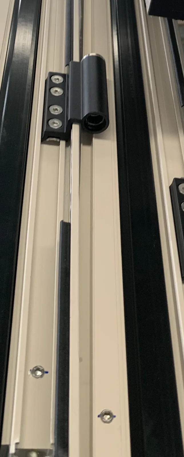 Close factory view of window tracks, hinges and operable panels after privacy redaction.